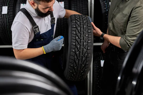 Owner garage shop holding best tire in a supermarket mall — Stockfoto