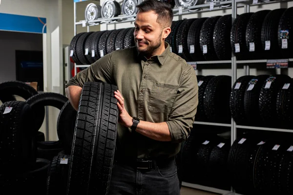 Male customer is satisfied with purchase of tyre in automobile repair garage. — Foto Stock