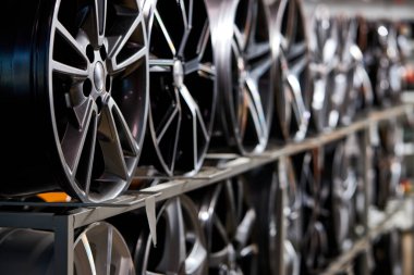 stand with alloy wheels in modern tire store, close up