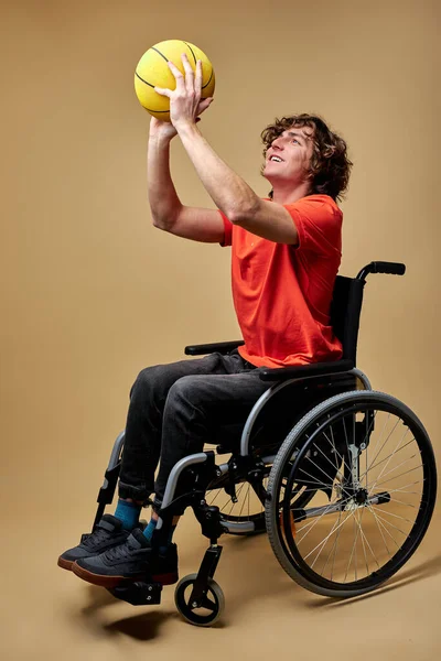 Handsome disabled caucasian man in wheelchair train with basketball ball — Stockfoto