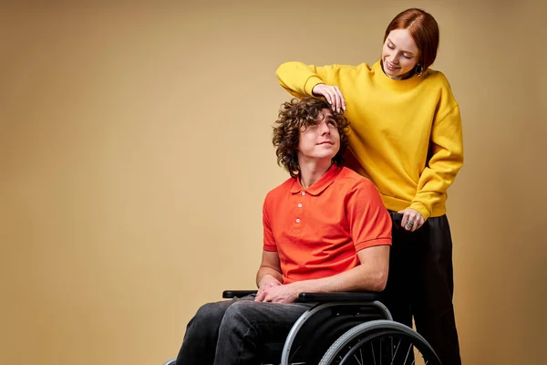 Feeling support. disabled young man enjoying time his beautiful kind girlfriend taking care of him — Stockfoto