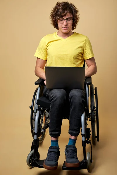 Talented disabled man is typing message on laptop keyboard — стоковое фото