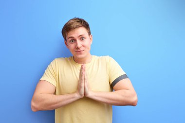 Sevimli gözlü çekici bir adam, dua ederken ya da yalvarırken gülümseyen ve iyilik isteyen.