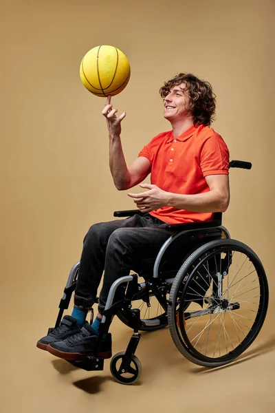 Fröhlicher behinderter Mann dreht den Ball am Finger — Stockfoto