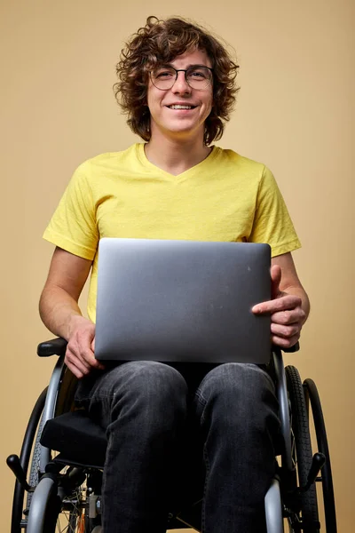 Behinderter Kaukasier sitzt im Rollstuhl mit Laptop — Stockfoto