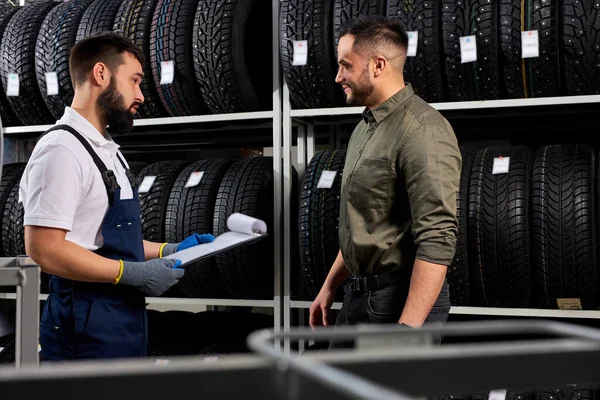 Meccanico auto affabile in uniforme aiutare il cliente con scelta — Foto Stock