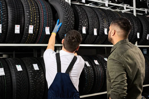 Il venditore offre nuove ruote in gomma, pneumatici, cerchioni per l'auto — Foto Stock