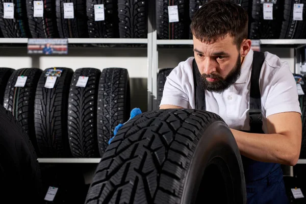 Selbstbewusster Automechaniker-Verkäufer untersucht Reifenoberfläche — Stockfoto