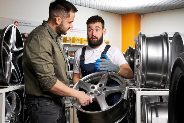 Ritratto di piacevole cliente e fiducioso meccanico auto parlando di ruote auto — Foto Stock