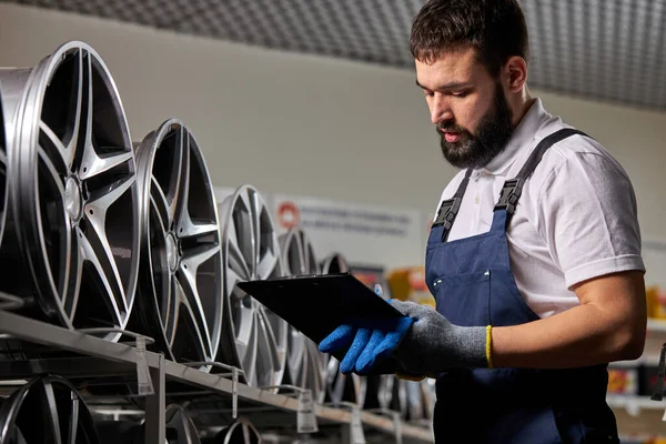 Zelfverzekerde reparateur maakt notities in papieren tablet — Stockfoto