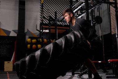 Aktif bir adamın yan görüntüsü, sıkı çalışma, uygun bir eğitimde lastiği patlatma.