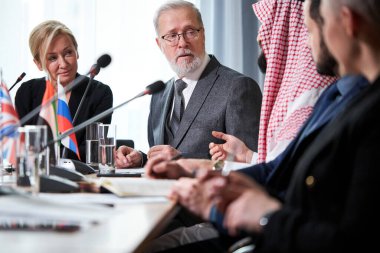 Uluslararası iş adamlarından oluşan bir grup çalışıyor ve iletişim kuruyor.