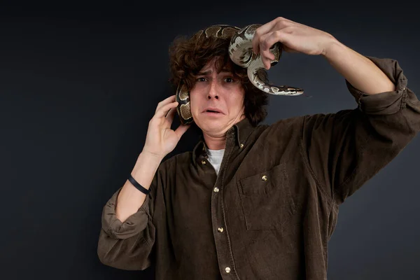 El hombre tiene pánico, está tratando de quitar una serpiente viva de sí mismo —  Fotos de Stock