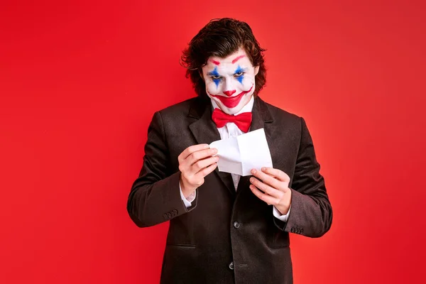 Handsome male magician performing a trick with hands isolated on red background — Stock Photo, Image