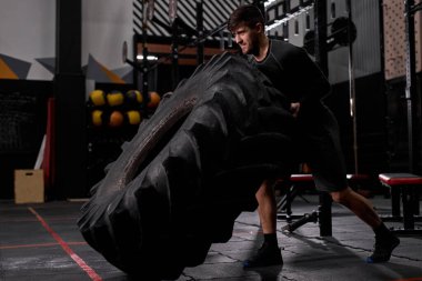 Aktif bir adamın yan görüntüsü, sıkı çalışma, uygun bir eğitimde lastiği patlatma.