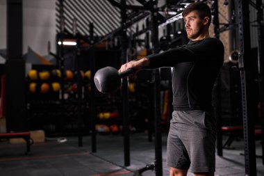 Genç zinde bir adam spor salonunda çan kaldırıyor.