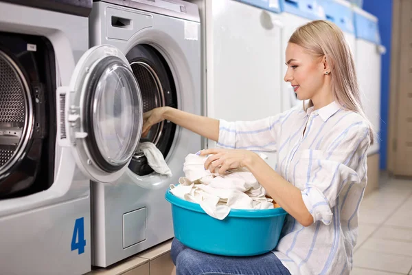 Caucasian woman doing the daily chores - laundry. Female folded clean clothes in the laundry basket