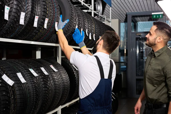 retirement man touching and choosing for buying a tire, measuring rubber car wheel