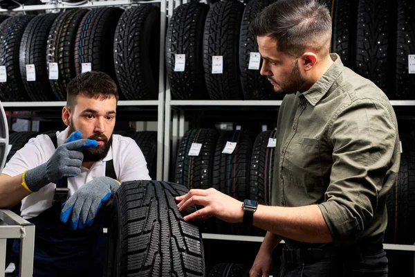 auto mechanic talk about advantages of auto tire to young client in service