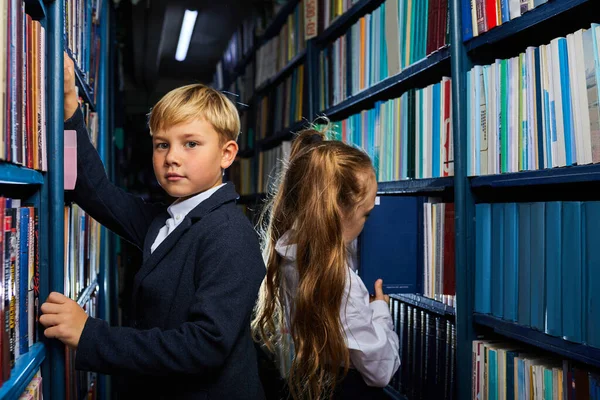 School children in library choosing books — Stock Photo, Image