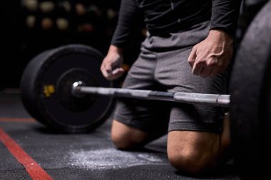 Kesilmiş sporcu halterle çömelme egzersizi yapacak. Beden eğitiminde çapraz fit.