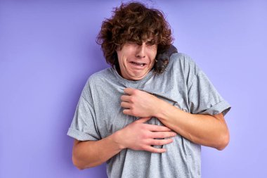 Meraklı gri dekoratif bir sıçan bir adamın omuzlarında sürünüyor.