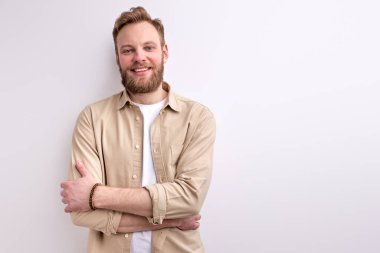 Kamerada sıradan pozlar veren beyaz sakallı genç adam.