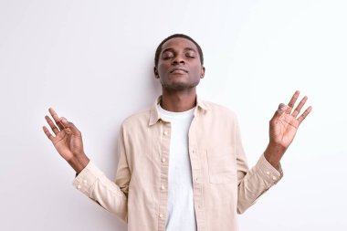 Sakin siyah Afrikalı erkek sakin ol, yoga pozisyonunda meditasyon yap.