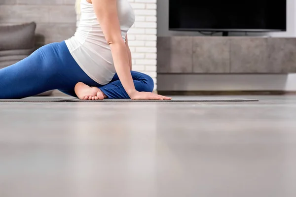 Засеянная беременная кавказка тренирует йогу дома — стоковое фото