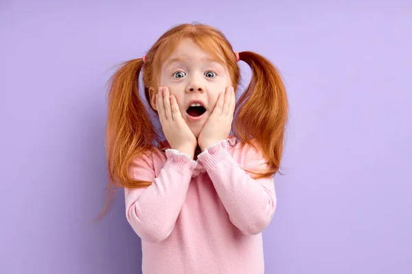 Szép kis meglepett lány gyömbér vörös haj és szeplők, áll felett lila háttér megható arc — Stock Fotó