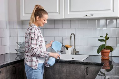 Hoş, beyaz bir kadının portresi, Masadan ve lavabodan kiri temizliyor.