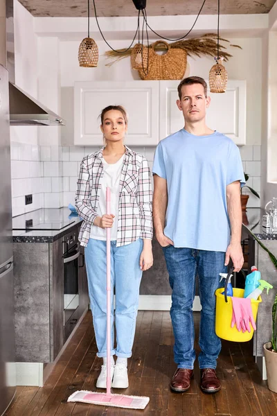 Retrato de conserjes caucásicos confiados hombre y mujer de pie en casa antes de la limpieza, limpieza — Foto de Stock