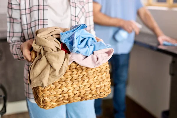 Imagen recortada de la mujer sosteniendo cesta de ropa llena de ropa, va a lavar —  Fotos de Stock