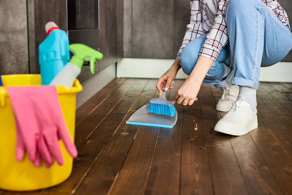Mulher irreconhecível varrendo poeira com escova e pó, segurando vassoura e varrendo o chão, coletando poeira em dustpan — Fotografia de Stock