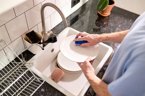 Manos masculinas recortadas lavando platos en el fregadero de la cocina mientras se hace la limpieza en casa los fines de semana, vista superior —  Fotos de Stock