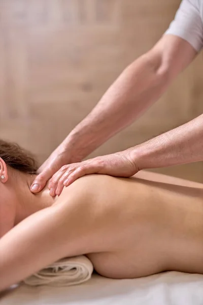 Masaje de espalda para mujer joven en el moderno salón de spa. Recuperación muscular después del ejercicio. Bienestar. Tratamiento de espalda. masaje deportivo. — Foto de Stock