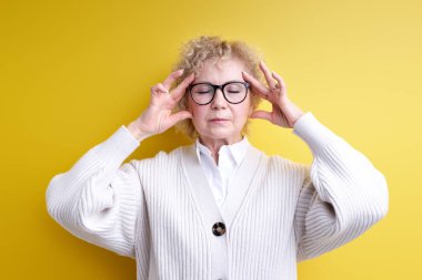 Gergin ve hayal kırıklığına uğramış görünen, baskı altında çalışan, baş ağrısı olan ve sorunları olan çekici bir kadın.