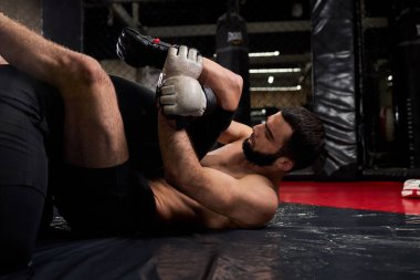 Boksörler ringin sekizgeninde kuralsız dövüşürler. Üstsüz dövüşçü boğma resepsiyonunda