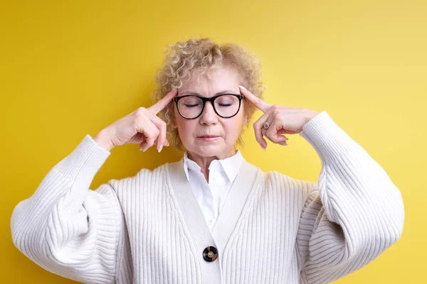 Starší atraktivní žena vypadá vystresovaná a frustrovaná, pracuje pod tlakem s bolestí hlavy a trápí se problémy — Stock fotografie