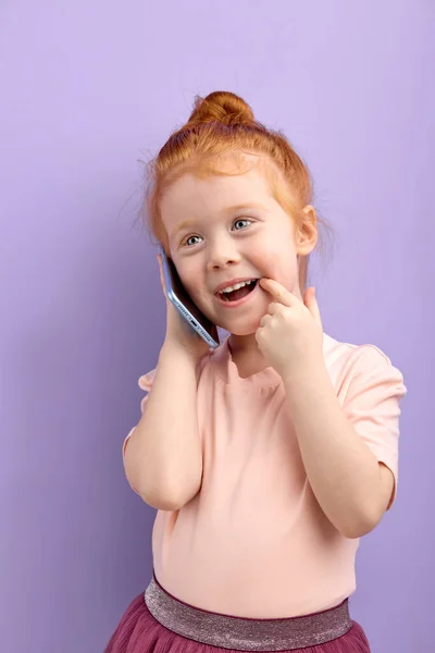 Niña pelirroja hablando por teléfono en el interior. concepto de adicción de los niños y gadgets — Foto de Stock