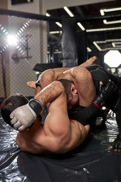 Dois atletas MMA chão lutando, preparando-se para o Campeonato em artes marciais mistas — Fotografia de Stock