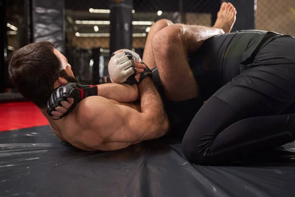 Vista lateral em dois lutadores profissionais lutando no ginásio. Boxers fortes com corpo perfeito lutando — Fotografia de Stock