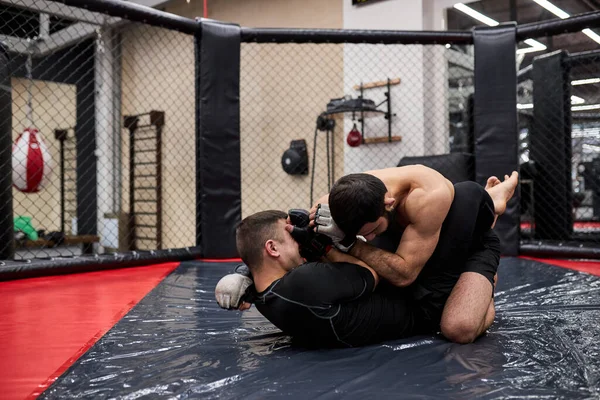 Boční pohled na profesionální boxery v dynamické boxerské akci na ringu v tělocvičně. Boxer zasáhl soupeře — Stock fotografie