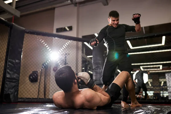 Artiste martial mixte homme en noir usure gagner, se tenir sur le combattant perdant — Photo