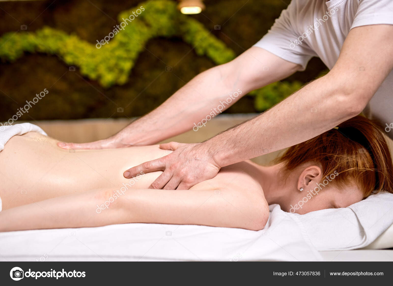 Young woman receiving a back massage in a spa center stock photo
