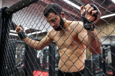 Karışık Dövüş Sanatları. Sekizgen 'de güçlü bir dövüşçü ringden ringe çıkıp dinleniyor.