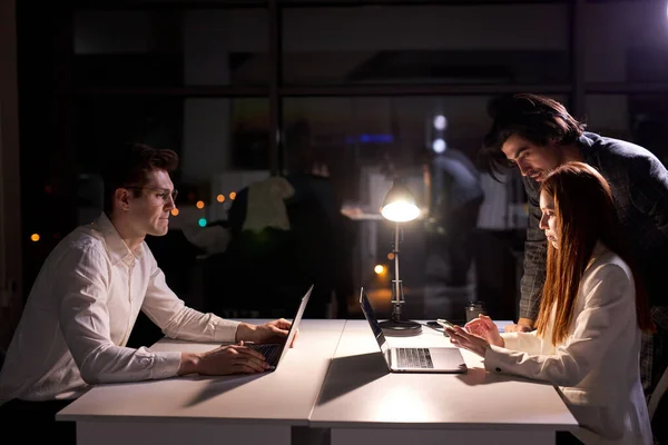 Kreatív emberek dolgoznak éjjel a tanácsteremben, munkatársak dolgoznak a számítógépen — Stock Fotó