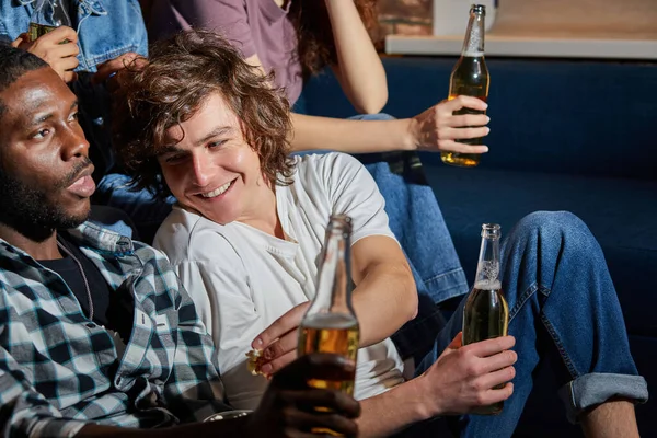 Grupo Interracial de amigos comiendo palomitas de maíz y bebiendo cerveza en casa, disfrutan viendo películas — Foto de Stock