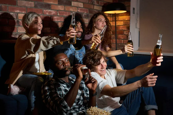 Emocionados estudiantes hombres y mujeres apoyando a su equipo deportivo favorito, bebiendo cerveza, animando emocionalmente — Foto de Stock