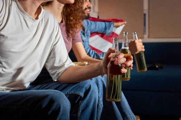 Amigos recortados pasando el rato en casa acurrucados en el sofá juntos emocionados viendo el evento de fútbol en la televisión — Foto de Stock